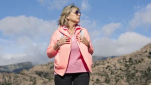Mature woman standing in morning sunlight to support heart health after 60.