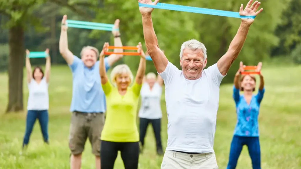 Older adults performing outdoor resistance band exercises in sunlight to support bone density, vitamin D, and healthy aging.