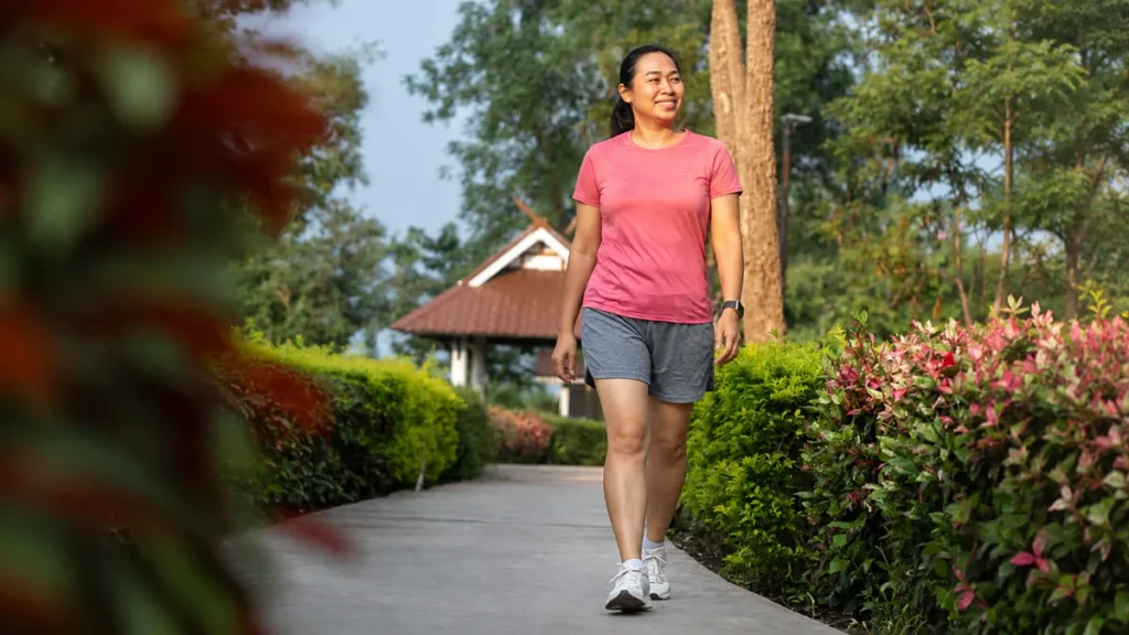 Mature south Asian woman in her late walking briskly outdoors in morning light, reflecting the physical vitality that returns after cutting excess sugar.