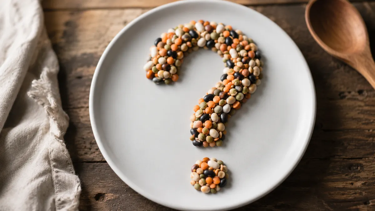 Mixed beans and lentils arranged in the shape of a question mark on a white plate, symbolizing the mystery longevity food most people overlook.