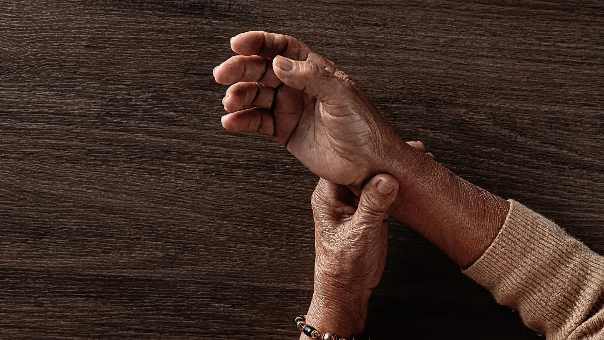 Close-up of elderly hands showing wrist joint pain and limited mobility, illustrating a potential decline in grip strength.