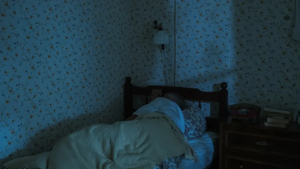 Calm, dark bedroom setup supporting better sleep habits for seniors over 65.