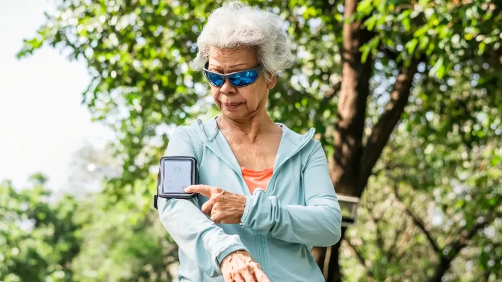 A fitness tracker on a mature wrist displays a heart rate of 125 beats per minute for Zone 2 training.