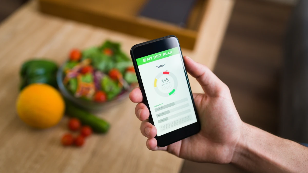 A person uses a nutrition tracking app on a smartphone to monitor intake.