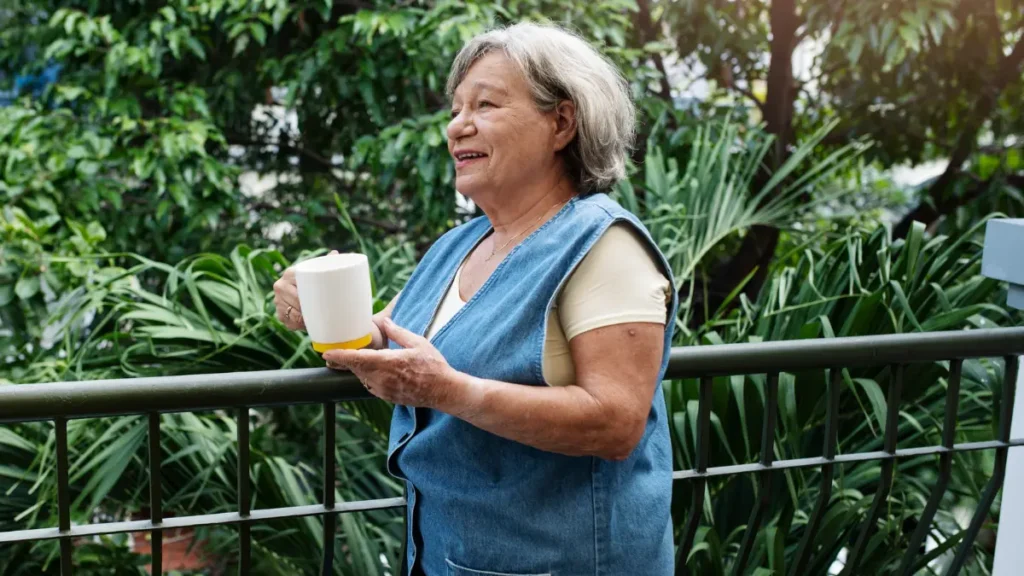 A mature woman enjoys a peaceful glimmer moment with a cup of coffee to shift the brain out of stress mode.