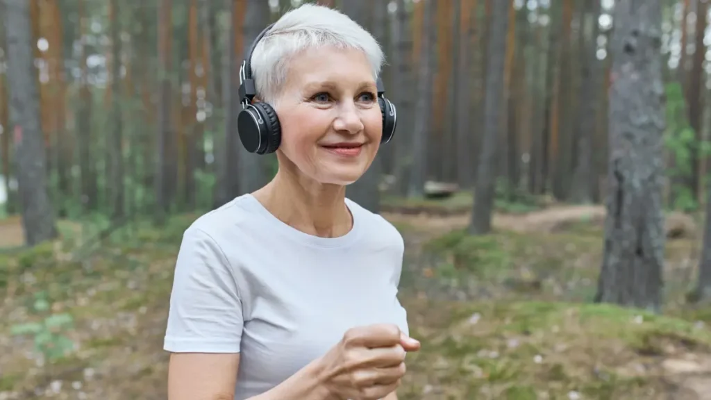 A mature woman maintains a steady walking pace to demonstrate the Zone 2 talk test.