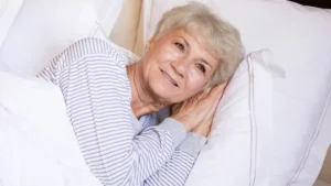 Calm senior woman falling asleep naturally after a guided breathing protocol for insomnia.
