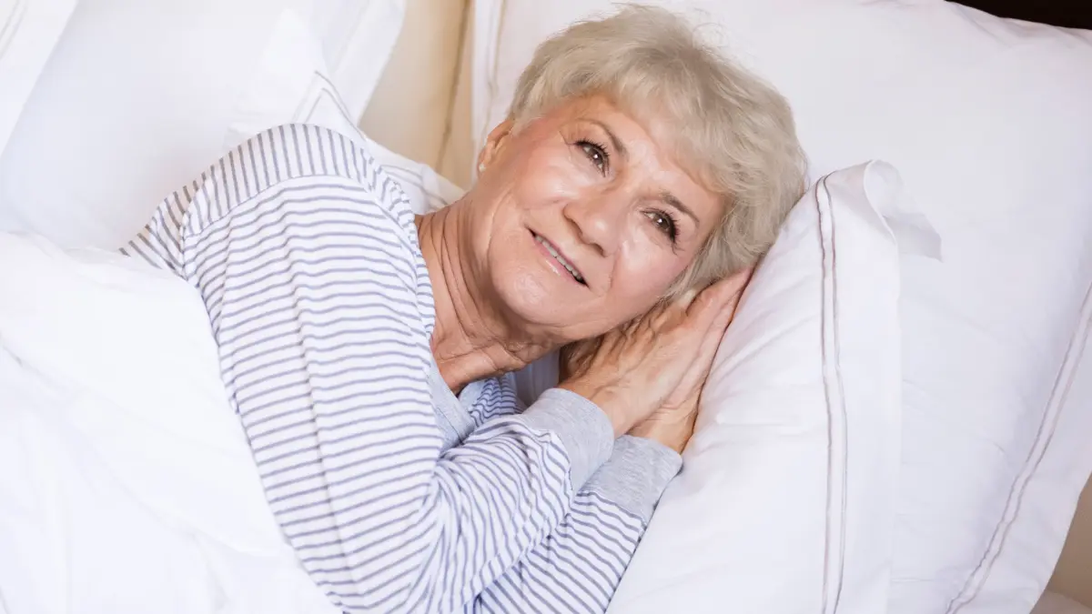 Calm senior woman falling asleep naturally after a guided breathing protocol for insomnia.