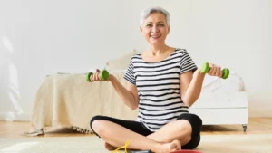 Mature woman with silver hair performs bone strengthening exercises in a sunlit home gym
