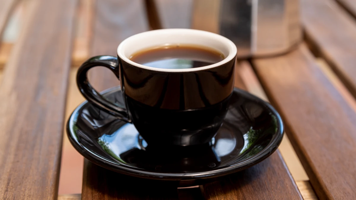 Cup of black coffee on table, hydrating zero-calorie beverage that may help reduce kidney stone risk 