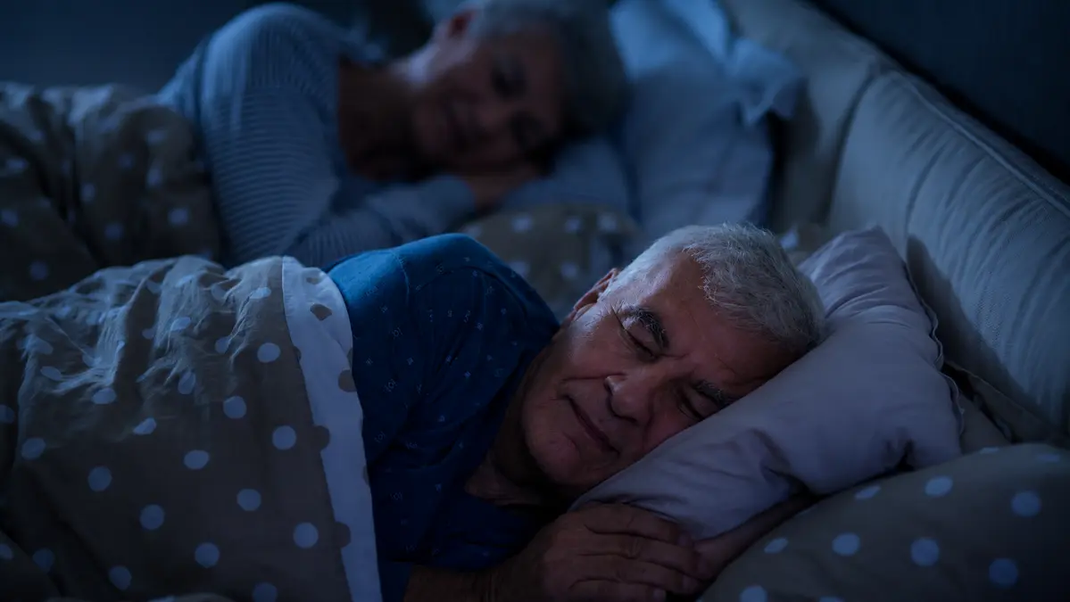 Older couple sleeping peacefully at night, illustrating how deep sleep supports brain health, memory, and mental clarity.