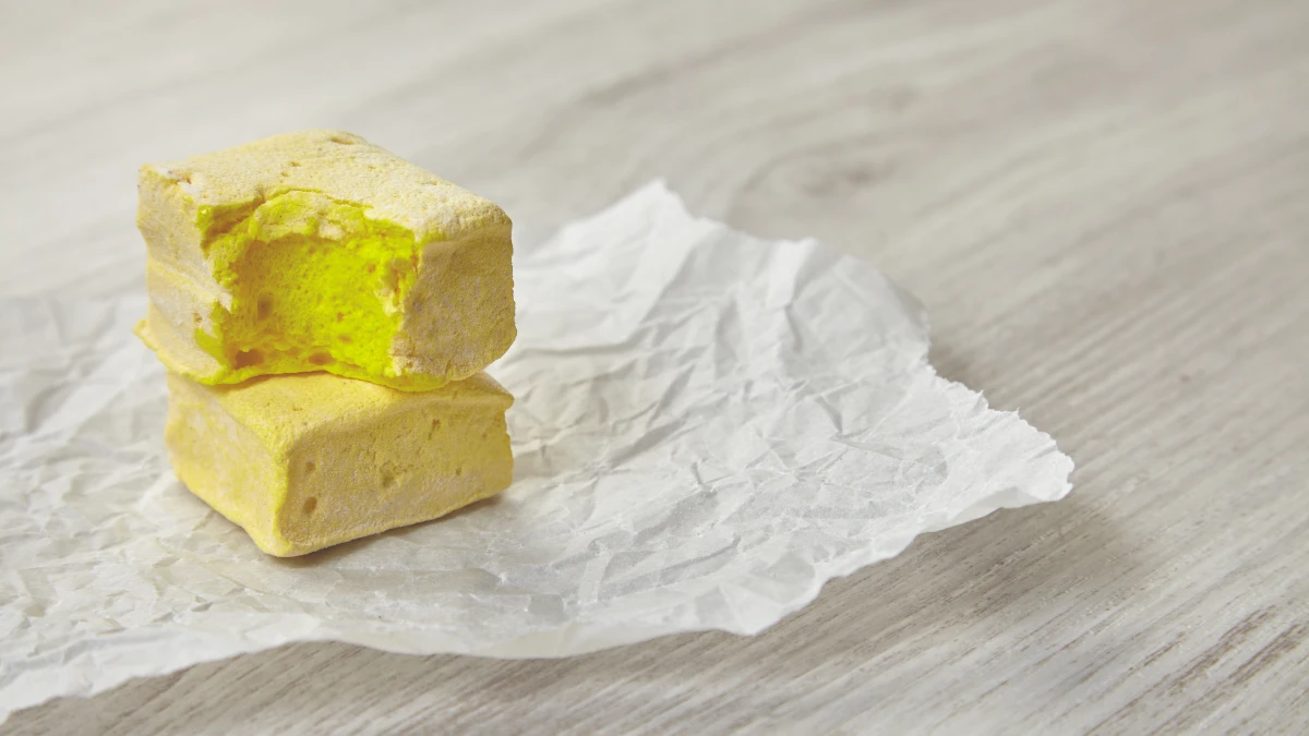 Thick slice of golden grass-fed butter melting on green vegetables, aiding Vitamin D3 absorption for bone health.