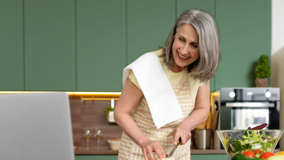 Woman prepares a fresh spinach salad with sliced potatoes to maintain a healthy diet for hearing through proper nutrition