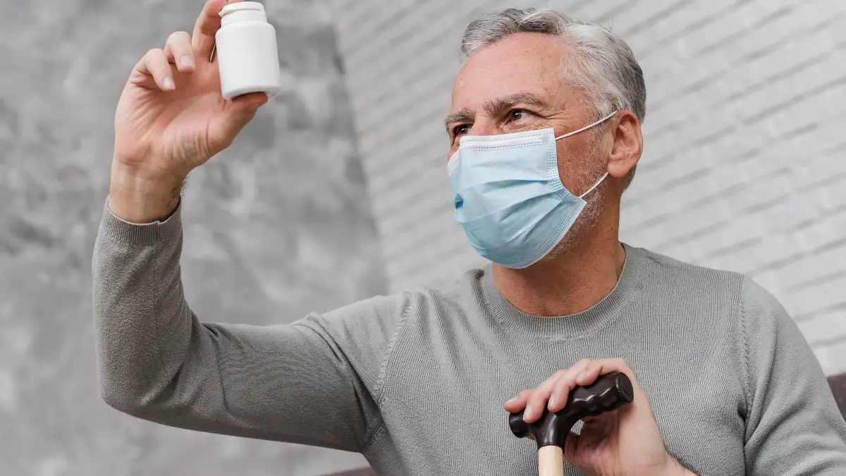 A senior examines the nutritional label on a liver supplement bottle.