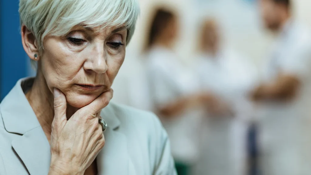 Distraught senior woman with hand on chin, reflecting on how low B12 affects brain cell health