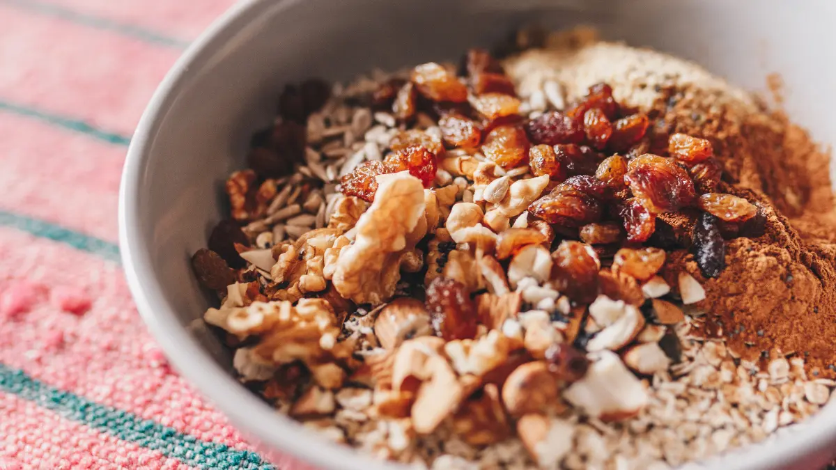 Boron for hormones included as an older man adds walnuts and raisins to his evening quinoa power bowl.