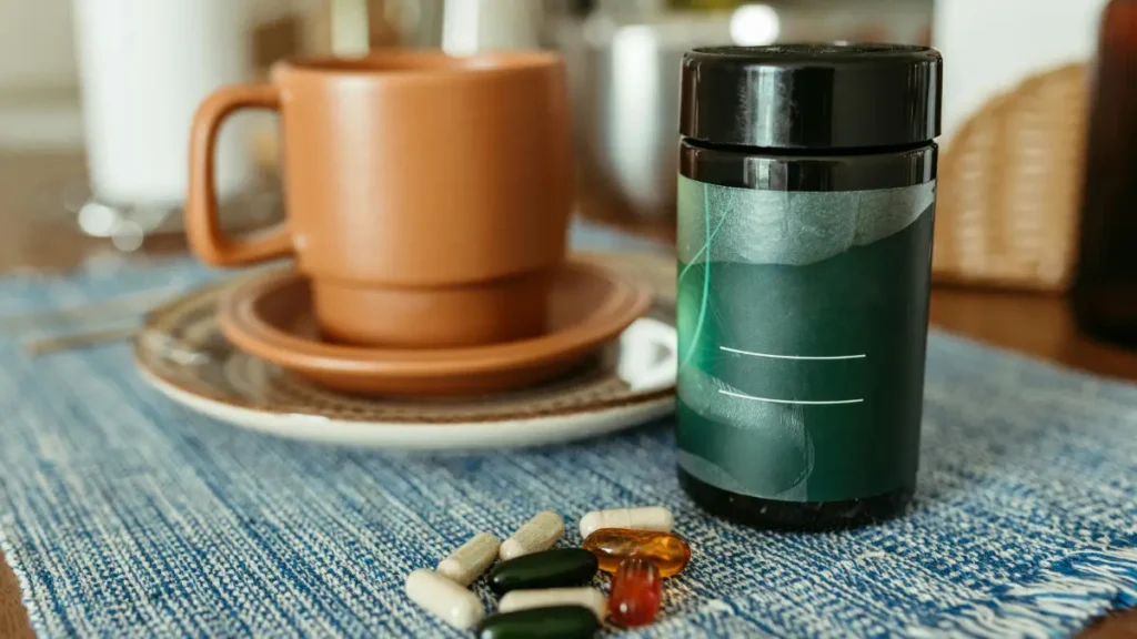 Natural light still life featuring a supplement bottle and various capsules like Benfotiamine and ALA on a blue woven mat, representing an anti-glycation wellness routine.