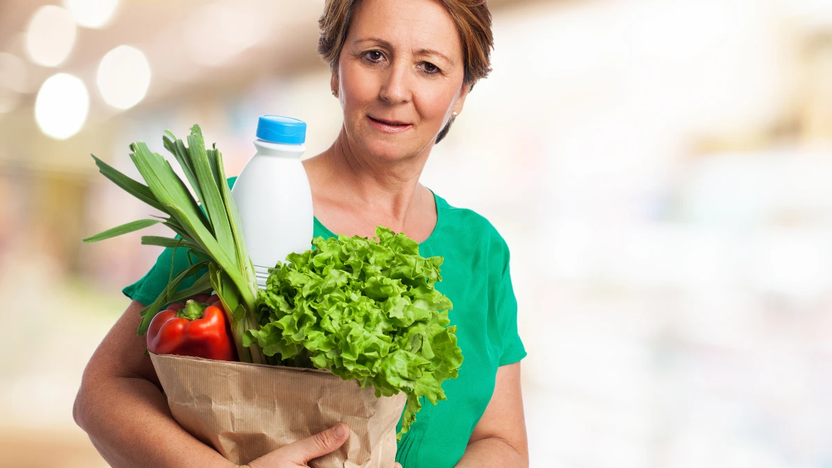 Mature woman confidently carrying a bag of fresh groceries, illustrating improved grip strength and everyday ease.