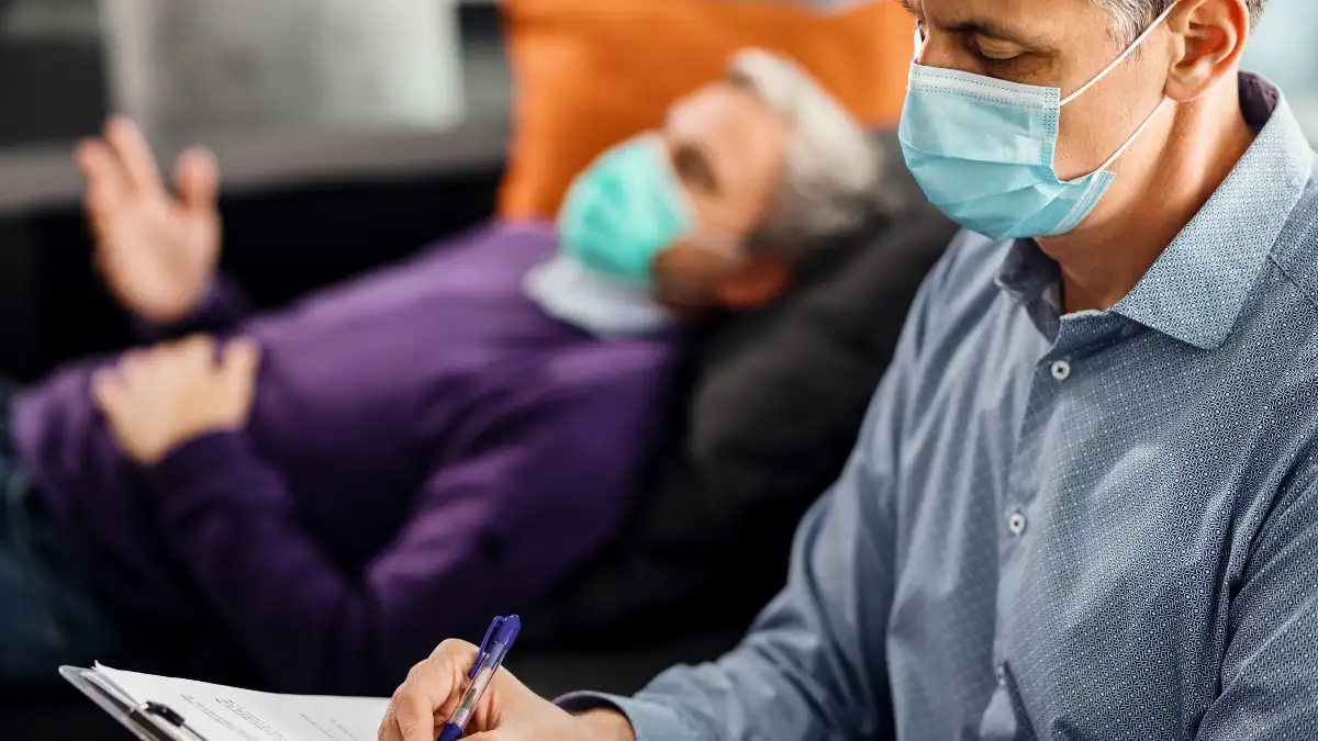  Doctor reviewing sleep study results with older male patient discussing sleep apnea diagnosis and treatment options.