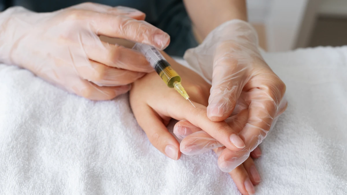 Healthcare professional administering a precise injection into a finger at a low angle for effective nerve repair. 