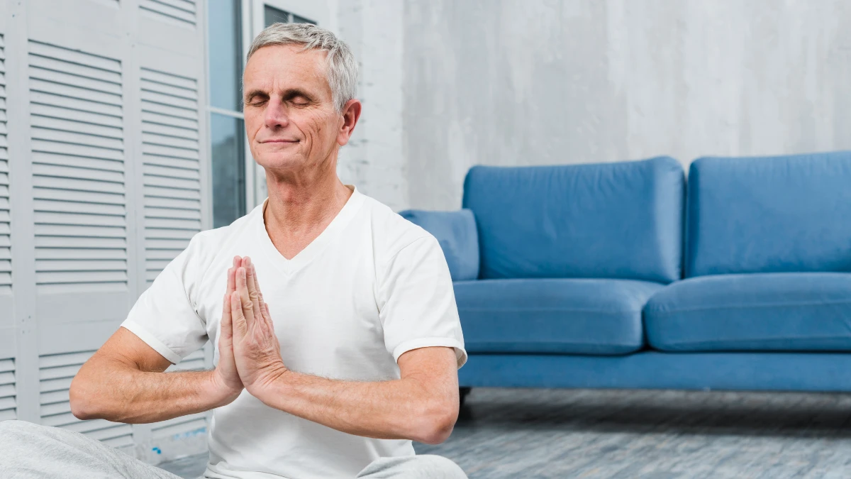 Mature man breathing deeply with eyes closed, facilitating cortisol management to accelerate muscle fiber repair.