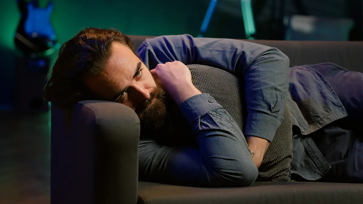 Restless senior man lying on sofa at night showing how poor sleep and sleep apnea stiffen arteries.