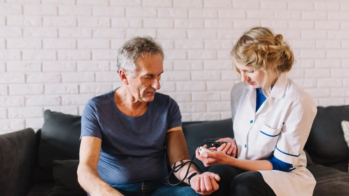 Man in his 60s looking thoughtfully at blood pressure reading, questioning if numbers hide true arterial stiffness