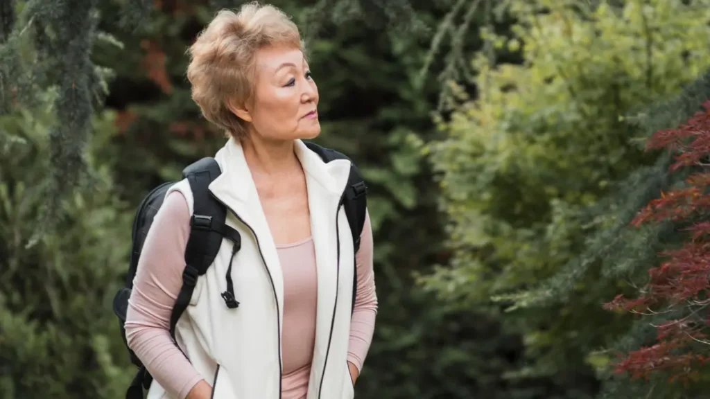 Active woman in her 60s taking a gentle walk to promote gastric emptying and natural movement after a meal.