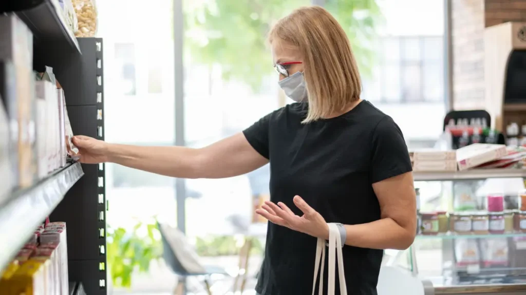 A women in her 50s checking a label for maltodextrin to prioritize cortisol management through clean ingredients.