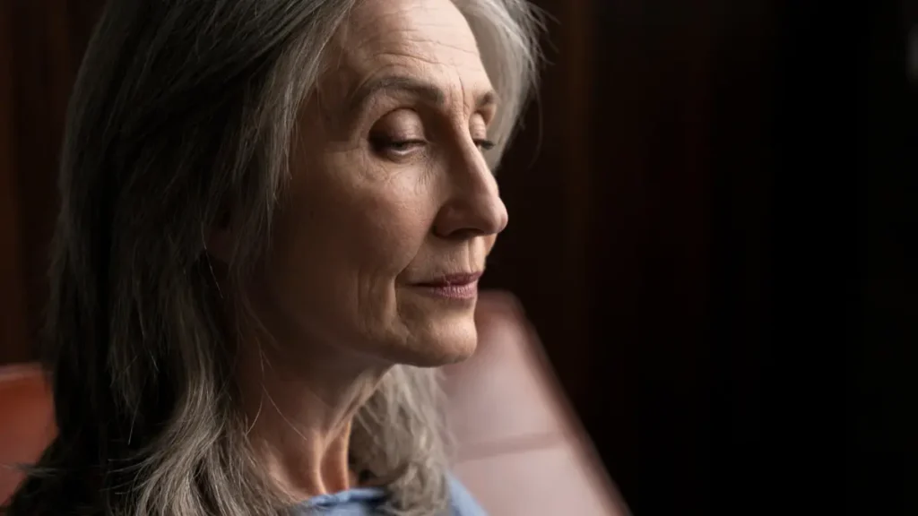 Mature woman experiencing cortisol-related sleep disruption and the tired but wired feeling after 50.