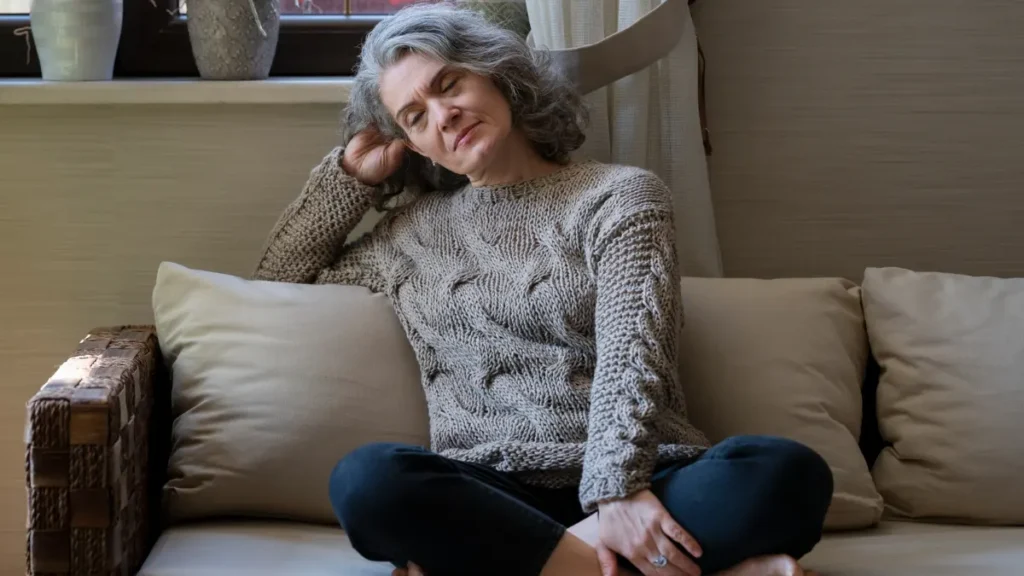 Mature woman resting on a sofa to recover from the persistent fatigue of inflammaging.