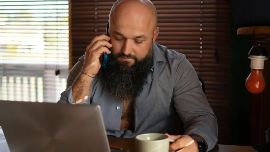 Stressed man at a desk drinking coffee while managing cortisol levels.