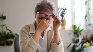 Mature woman experiencing eye grit and blurred focus linked to metabolic heat production and systemic inflammation.