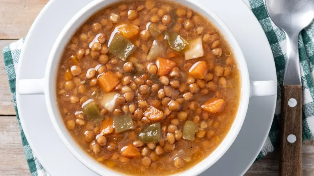 Warm lentil vegetable soup served at dinner to provide high-fiber carbohydrates that support melatonin production and better sleep.