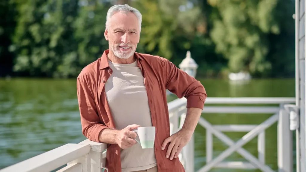 Mature man standing outdoors in morning sunlight to reset his internal clock and stabilize his 24-hour cortisol rhythm.