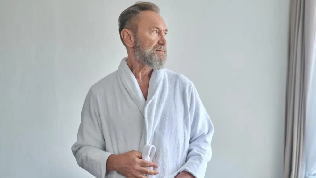 Man stepping out of a warm bath to lower core body temperature for deep sleep.