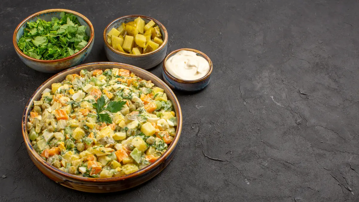 Cold potato salad with vegetables and herbs in a bowl, a resistant starch meal that supports gut health and lowers blood sugar spikes.