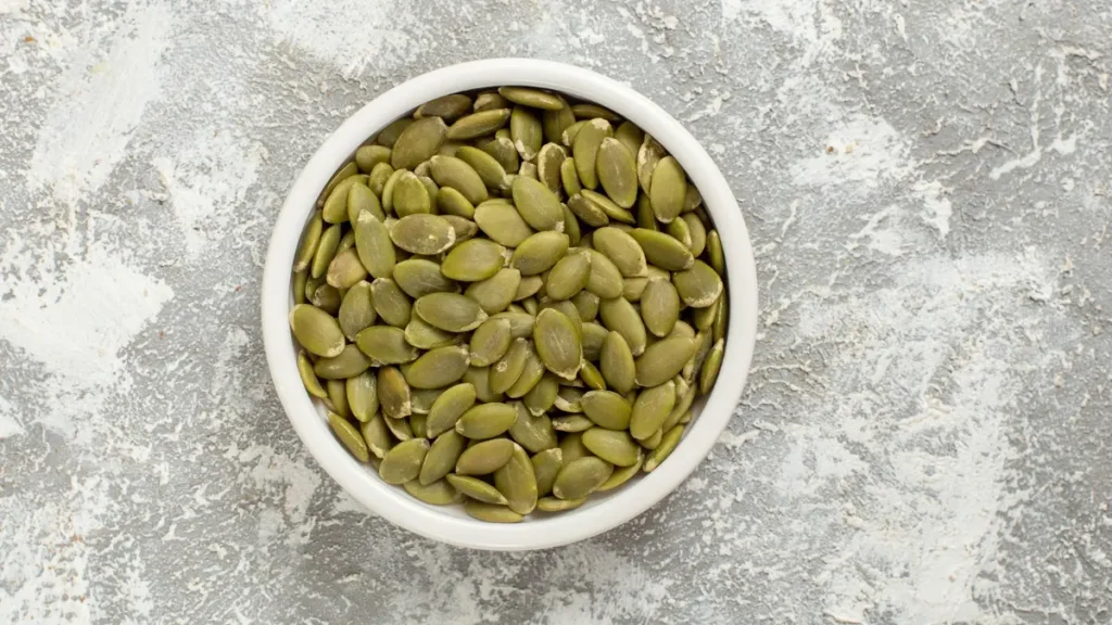 Top view of raw pumpkin seeds in a bowl to support natural zinc levels and avoid the copper see-saw effect.