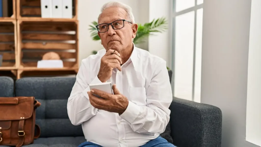 Mature man using a notepad to manage cognitive load and support cortisol management during a memory lapse.