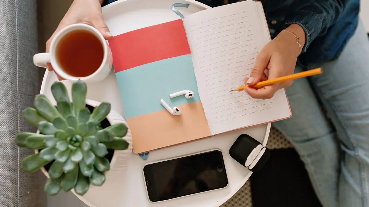 A focused person writing a list of questions in a small notebook to prepare for an accurate mineral panel request