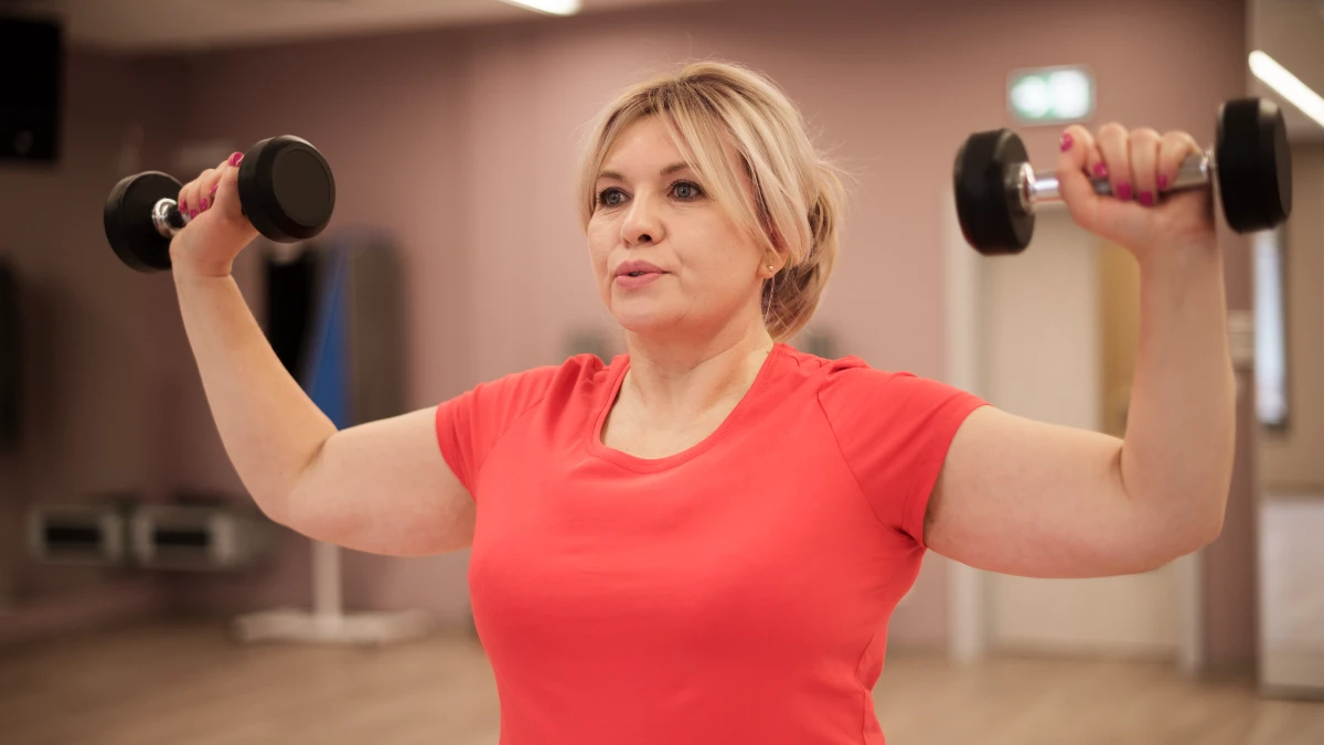 Active woman in her 60s practicing resistance training to improve basal metabolic rate and utilize dietary protein for muscle repair.