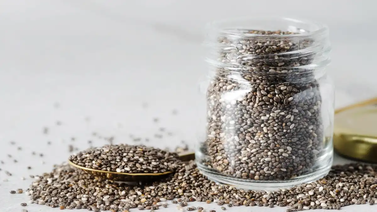 Organic chia seeds in a glass jar, a high-fiber superfood used as a healthy addition to smoothies and oatmeal.