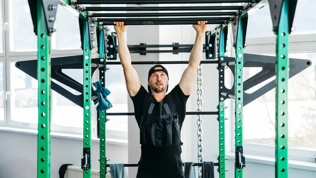 Man performing a dead hang with an overhand grip on a pull-up bar to decompress the spine and build lasting grip endurance