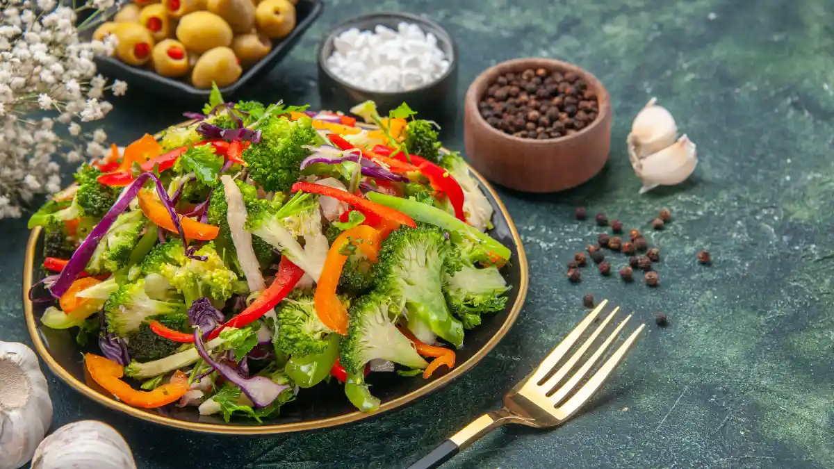 A vibrant vegetable salad featuring broccoli and bell peppers sits ready to create a digestive fiber buffer against post-meal energy crashes