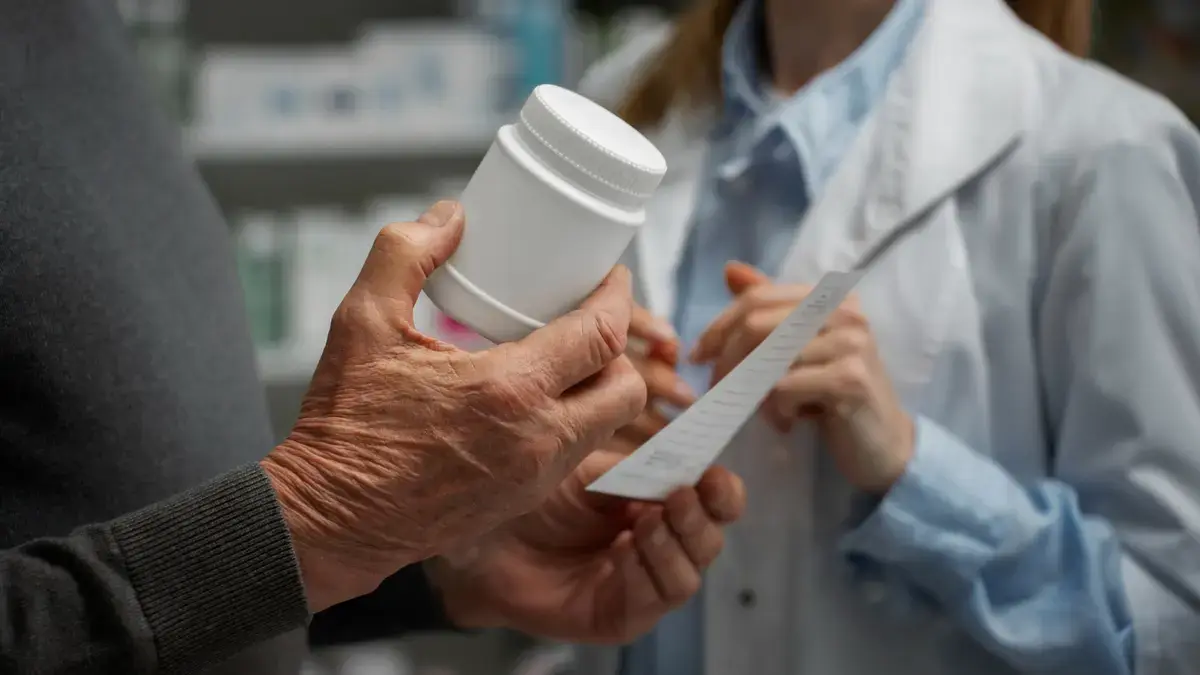 Senior man checking a supplement label for methylfolate to avoid MTHFR gene mutation symptoms.