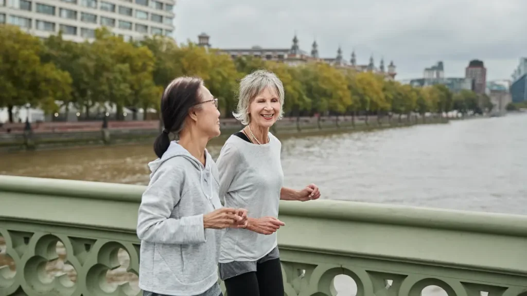 Mature womans walking at a conversational pace on a sunny trail to optimize zone 2 cardio for womens over 50