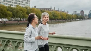 Mature womans walking at a conversational pace on a sunny trail to optimize zone 2 cardio for womens over 50