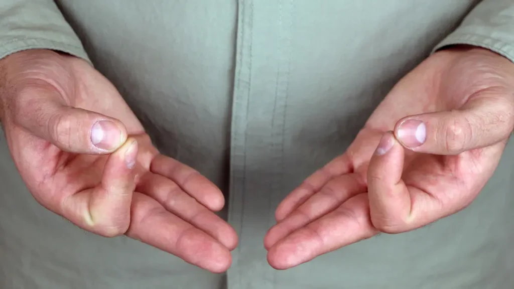 Close up of mature hands performing a thumb-to-index finger tap to improve precision and neuromuscular coordination.