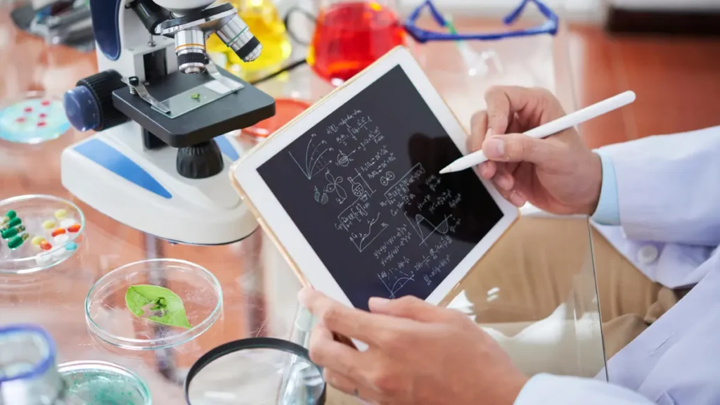 A scientist analyzes clinical study data on a tablet next to a microscope to evaluate human blood glucose responses.