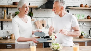 Active mature couple preparing a nutrient-dense meal to support metabolic heat production and healthy aging after 50.